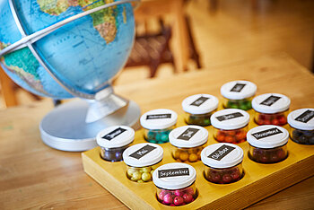 Bunte Perlen in Gläschen zum Monate erlernen