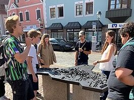 SchülerInnen stehen um einen Stadtplan aus Metall